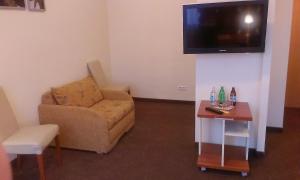 a living room with a couch and a tv on a wall at Hotel & SPA Odeon in Boguchwała