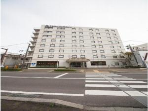 um grande edifício branco com uma faixa de pedestres em frente em Hotel St Palace Kurayoshi - Vacation STAY 82276 em Kurayoshi