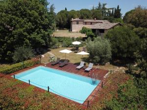 uma vista superior para uma piscina com cadeiras e guarda-sóis em Borgo dei Fondi em Siena