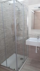 a shower with a glass door next to a sink at B&B Filieri in Santa Maria al Bagno