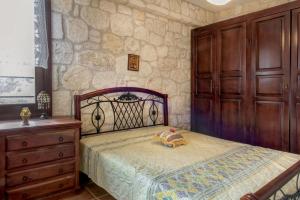 a bedroom with a bed and a wooden dresser at Danai House in Nea Roda