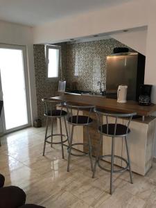 a kitchen with three bar stools and a counter top at Studio Apartments MT in Šmrika