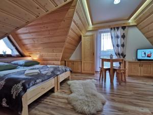 ein Schlafzimmer mit einem großen Bett und einer Holzdecke in der Unterkunft Pokoje Gościnne Kurosik in Zakopane