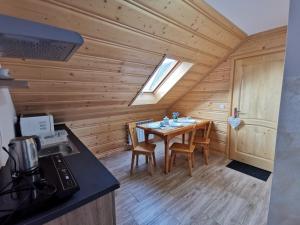 a dining room with a table in a log cabin at Pokoje Gościnne Kurosik in Zakopane