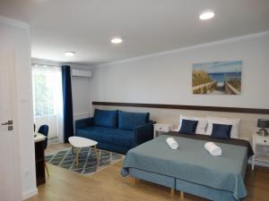 - une chambre avec un lit bleu et un canapé bleu dans l'établissement Willa Morska, à Mielenko