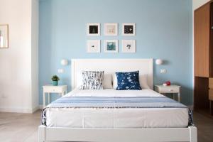 a bedroom with a white bed with blue walls at Casa Peonia in Tropea