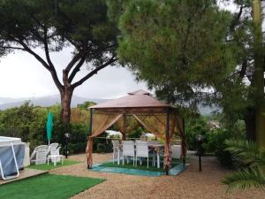 a gazebo with white chairs and a table at Lupetta in Lacona