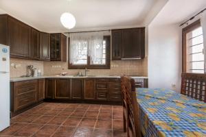 a kitchen with wooden cabinets and a sink and a table at Danai House in Nea Roda