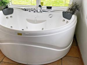 a white bath tub in a bathroom with a window at 7 person holiday home in R dby in Rødby