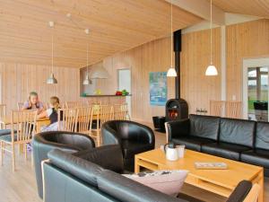 - un salon doté d'un mobilier en cuir noir et d'une table dans l'établissement 14 person holiday home in L kken, à Løkken