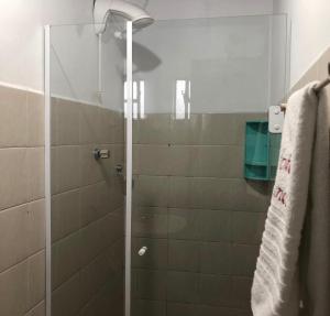 baño con ducha y puerta de cristal en Hotel Nunes, en Curitiba