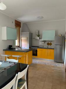 una cucina con armadietti gialli ed elettrodomestici in acciaio inossidabile di a casa di barbara a Galatone