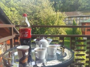 una botella de coca cola y tazas en una mesa en Cumurija Bridge Accommodation, en Sarajevo