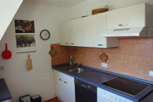 a kitchen with white cabinets and a sink at Am Strandweg in Überlingen