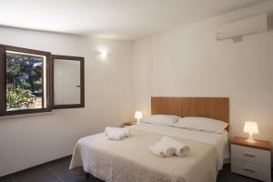 サン・ヴィート・ロ・カーポにあるVilletta Blusanvitoのベッドルーム1室(ベッド1台にタオル2枚付)