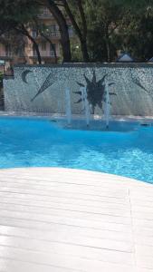 a fountain in a swimming pool with blue water at Hotel Villa La Colombaia in Portici