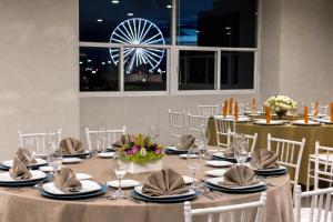 uma sala de jantar com uma mesa com cadeiras e uma roda gigante em Mision Puebla Angelopolis em Puebla