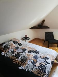 Un dormitorio con una cama con una manta. en * Maison aux portes de Troyes en Champagne *, en Sainte-Maure