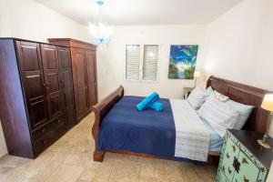 ein Schlafzimmer mit einem Bett mit einem blauen Kissen darauf in der Unterkunft El Trupial in Kralendijk