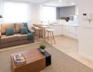 ein Wohnzimmer mit Sofa und Tisch in der Unterkunft CONCHEIROS 5 APARTAMENTOS TURISTICOS in Santiago de Compostela + 175 Fotos