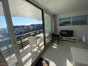 un soggiorno con vista su un balcone e TV di BEAU DUPLEX DEAUVILLE MARINA, F3 avec balcon a Deauville