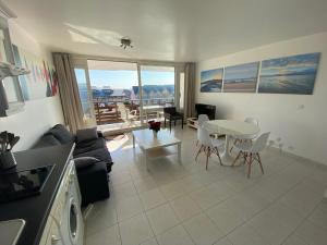 una cucina e un soggiorno con tavolo e sedie di BEAU DUPLEX DEAUVILLE MARINA, F3 avec balcon a Deauville