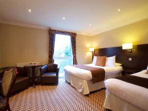 a hotel room with two beds and a chair at Liverpool Aigburth Hotel, Sure Hotel Collection by BW in Liverpool