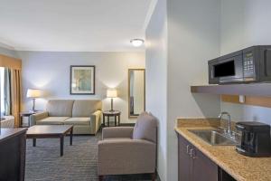 a living room with a kitchen and a living room with a couch at Sonesta Essential Houston Westchase in Houston