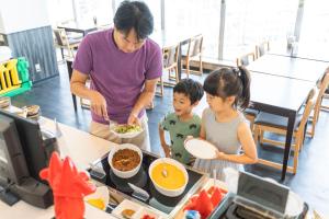 a woman and two children eating food from a buffet at Hotel Ocean (Kokusai-Dori) in Naha