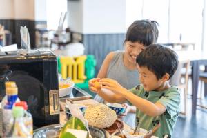 a woman and a boy preparing food in a kitchen at Hotel Ocean (Kokusai-Dori) in Naha