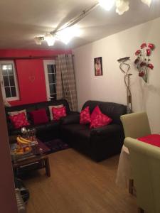 uma sala de estar com um sofá preto e paredes vermelhas em Beautiful Bungalow Home Droitwich SPA em Droitwich