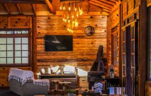 uma sala de estar com lareira num chalé de madeira em Pousada Caminhos da Natureza em Urubici