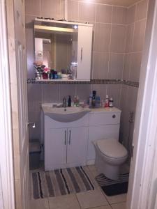 a bathroom with a sink and a toilet and a mirror at Beautiful Bungalow Home Droitwich SPA in Droitwich