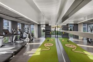 a gym with treadmills and a green carpet at 1 Hotel West Hollywood in Los Angeles