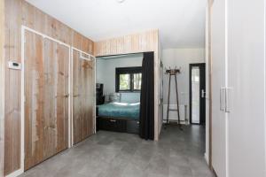 a bedroom with a bed and a closet with a mirror at Beach house in Erm