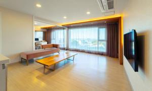 a living room with a couch and a table and a television at Pampas Resort in Sokcho