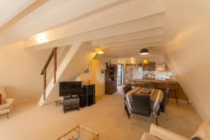 a living room with a dining table and a kitchen at Ahiparadise - Ahipara Holiday Home in Ahipara