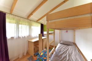 ein kleines Schlafzimmer mit einem Etagenbett und einem Schreibtisch in der Unterkunft LA LIVADA in Valea Danului