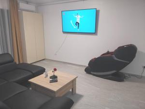 a living room with a couch and a tv on a wall at MaraVali Seaview Mamaia in Mamaia