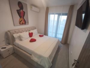 a bedroom with a bed with two red roses on it at MaraVali Seaview Mamaia in Mamaia