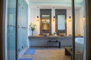 a bathroom with two sinks and two mirrors at Mia Resort Nha Trang in Nha Trang