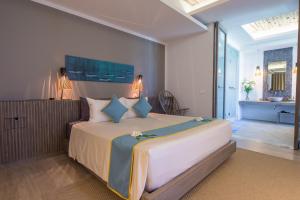 a bedroom with a large bed and a bathroom at Mia Resort Nha Trang in Nha Trang