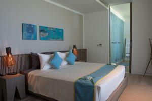 a bedroom with a large bed and a couch at Mia Resort Nha Trang in Nha Trang