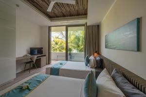 a bedroom with two beds and a couch at Mia Resort Nha Trang in Nha Trang