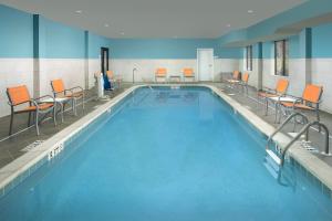 a large swimming pool with chairs and tables in a building at Holiday Inn Express Knoxville-Strawberry Plains, an IHG Hotel in Knoxville