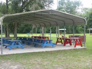 un grupo de mesas de picnic bajo un dosel en un parque en Deerwood Inn & Madison Campground, en Madison