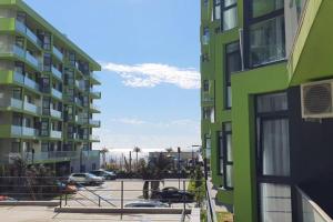 un edificio verde accanto a un parcheggio con auto di ZIAN'S Studio Mamaia Nord Beach Resort a Mamaia Nord - Năvodari