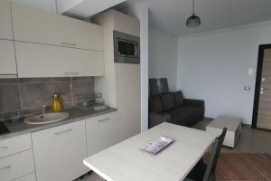 una cucina con tavolo, lavandino e divano di ZIAN'S Studio Mamaia Nord Beach Resort a Mamaia Nord - Năvodari