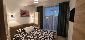 una camera da letto con un letto e una grande finestra di ZIAN'S Studio Mamaia Nord Beach Resort a Mamaia Nord - Năvodari