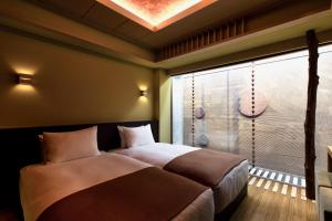 京都的住宿－eph KYOTO，一间卧室设有一张床和一个带淋浴的窗户。